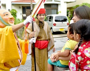 大きなうちわで福の風　沖縄・首里赤田町の「みるくウンケー」