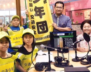 交通安全、大城ミヨさんに感謝　玉城小学校前で指導３５年　ＦＭなんじょうが特番
